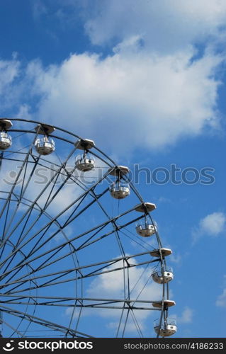 Part of Ferris wheel on blue sky background