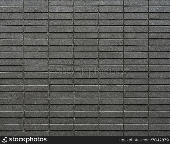part of grey brown brick wall with strait cement joints