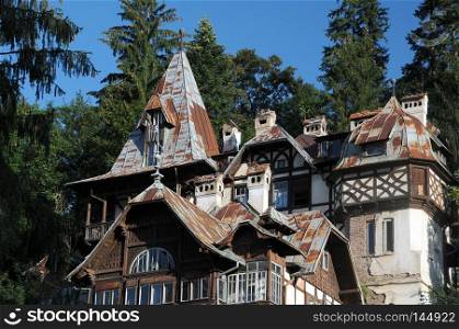 Part of old house in Sinaia, Romania, agaist the background of trees and blue sky