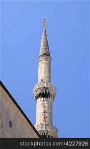 Part of one of the Blue Mosque minarets against blue sky background in Istanbul, Turkey
