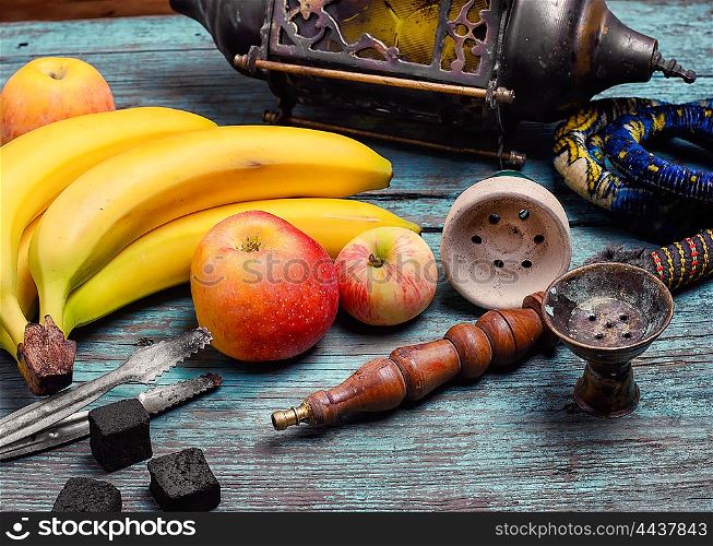 Part of the hookah,stylish arabic lamp and bananas with apple