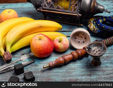 Part of the hookah,stylish arabic lamp and bananas with apple