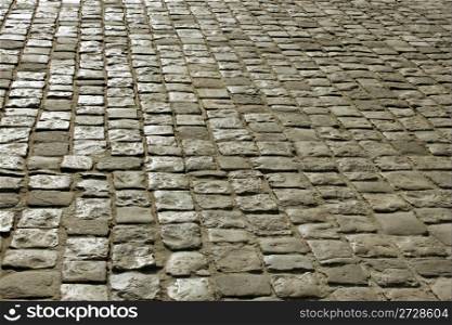 Part of urban square covered with cobblestone. Sunlight reflected on the stones