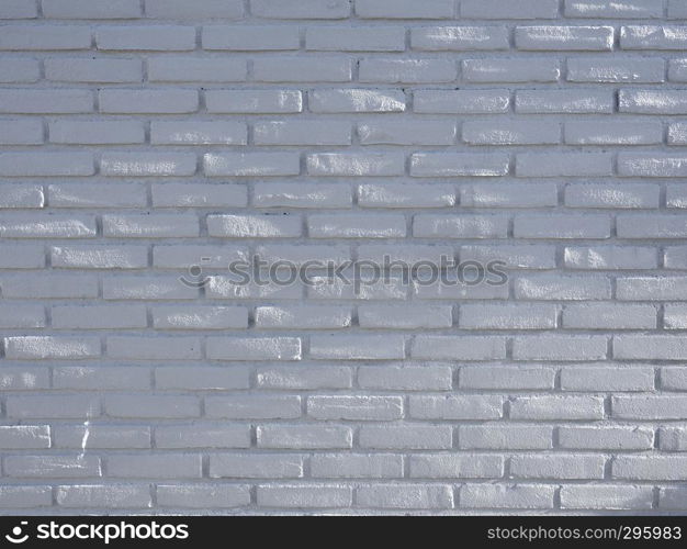 part of white gray brick wall with spots of sunlight