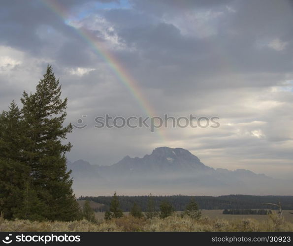 Partial rainbow over Mt. Moran on a cloudy day in the Tetons