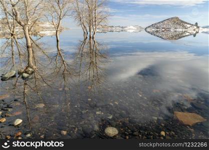 Partially frozen calm lake at foothills of Rocky Mountains - Horsetooth Reservoir, a popular recreation destination near Fort Collins in northern Colorado, winter scenery.