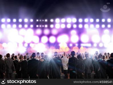 Partnership concept. Crowd of businesspeople standing with back with lights at background
