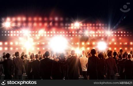 Partnership concept. Crowd of businesspeople standing with back with lights at background