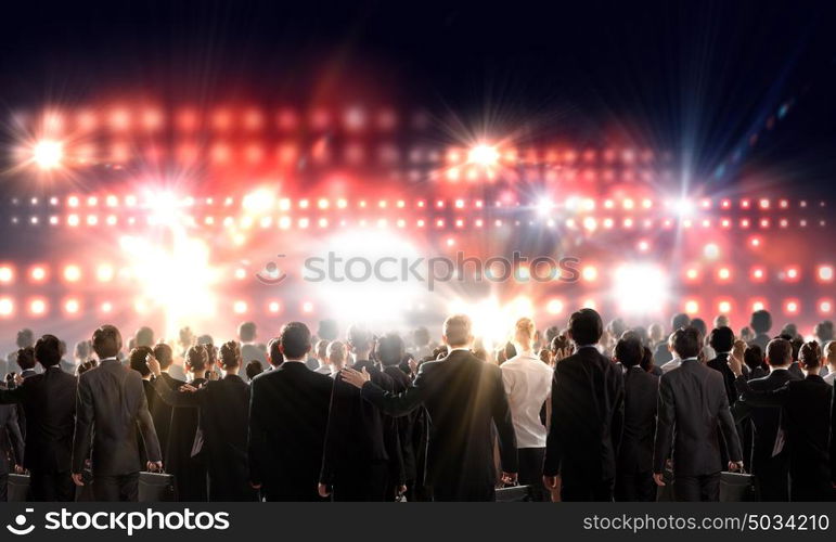 Partnership concept. Crowd of businesspeople standing with back with lights at background