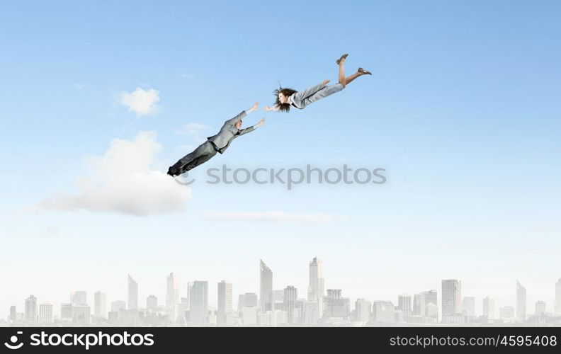 Partnership concept. Two young business people flying in sky