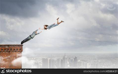 Partnership concept. Two young business people flying in sky