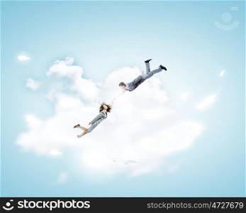 Partnership concept. Two young business people flying in sky