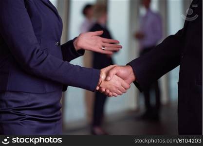 partnership concept with senior business man and woman make hand shake and take agreement in modern office interior