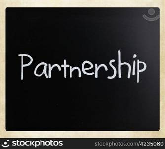 ""Partnership" handwritten with white chalk on a blackboard."