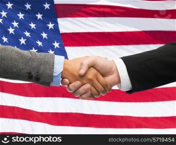 partnership, politics, gesture and people concept - close up of handshake over american national flag background