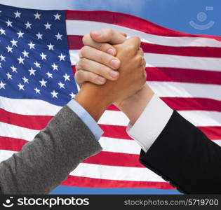 partnership, politics, gesture and people concept - close up of two hands armwrestling over american flag