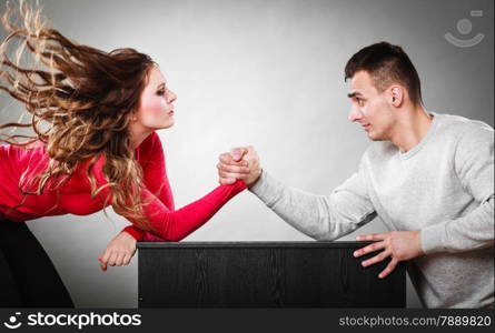 Partnership relationship concept. Girlfriend confronts his boyfriend. Woman and man arm wrestling challenge between young couple