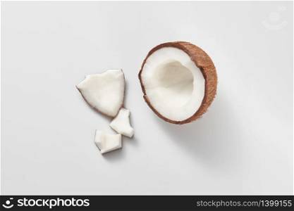 Parts of fresh natural organic tropical fruits coconut on a light grey background with copy space. Vegetarian concept.. Top view of fresh natural organic coconut&rsquo;s half on a light grey background.