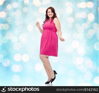 party and people concept - smiling happy young plus size woman posing in pink dress dancing background over blue holidays lights background. happy young plus size woman dancing in pink dress