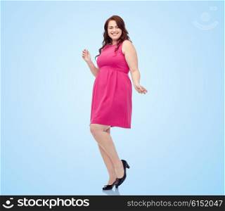 party and people concept - smiling happy young plus size woman posing in pink dress dancing over blue background. happy young plus size woman dancing in pink dress