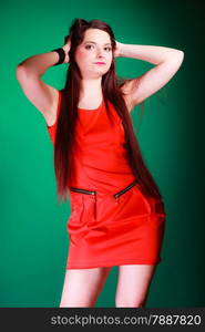 Party, celebration and date concept. Attractive young log hair woman in red dress on green background. Studio shot.