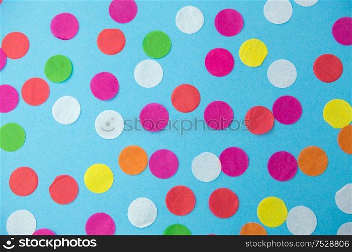 party, celebration and decoration concept - colorful confetti on blue background. colorful confetti decoration on blue background