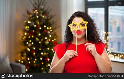 party, celebration and holidays concept - funny woman with star shaped glasses and red lips over christmas tree lights on home background. funny woman with star shaped glasses and red lips