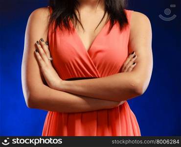 Party clothing evening fashion concept - attractive fashion woman, mixed race girl in orange elegant dress part of body bust dark blue background
