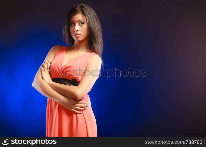 Party clothing evening fashion concept - Portrait attractive fashion woman, mixed race girl in orange elegant dress dark blue background. Copy text space