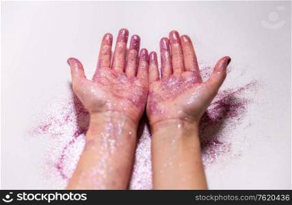 party, decoration and holidays concept - close up of hands with multicolored glitters on white background. hands with glitters on white background