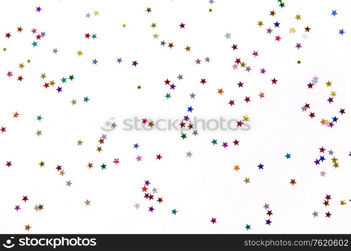 party, decoration and holidays concept - multicolored star shaped glitters on white background. star shaped glitters on white background