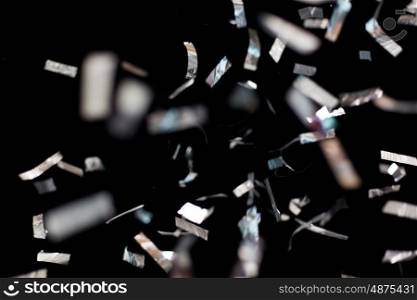 party, decoration and holidays concept - silver confetti over black background