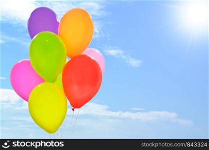 Party decoration concept - mix of colorful balloons on a blue sky background with copy space (mixed).