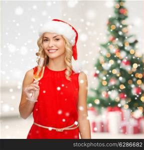 party, drinks celebration and people concept - smiling woman in santa helper hat and red dress with glass of champagne over living room and christmas tree background