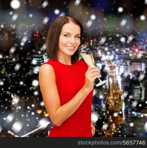 party, drinks, holidays, christmas and celebration concept - smiling woman in red dress with glass of sparkling wine over snowy night city background
