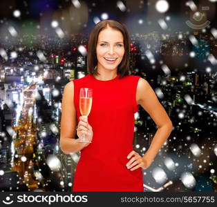 party, drinks, holidays, christmas and celebration concept - smiling woman in red dress with glass of sparkling wine over snowy night city background