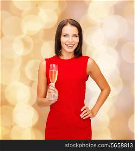 party, drinks, holidays, christmas and celebration concept - smiling woman in red dress with glass of sparkling wine over beige lights background