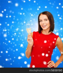 party, drinks, holidays, christmas and celebration concept - smiling woman in red dress with glass of sparkling wine over blue snowy background