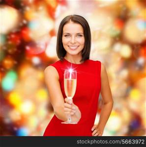 party, drinks, holidays, christmas and celebration concept - smiling woman in red dress with glass of sparkling wine over red lights background