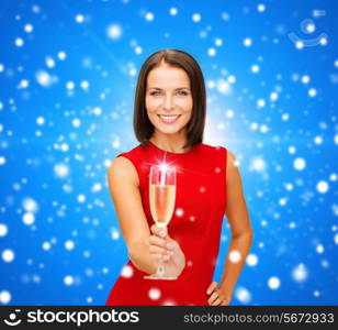 party, drinks, holidays, christmas and celebration concept - smiling woman in red dress with glass of sparkling wine over blue snowing background