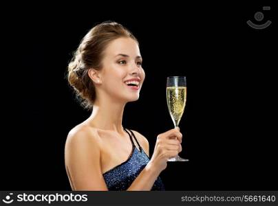 party, drinks, holidays, luxury and celebration concept - laughing woman in evening dress with glass of sparkling wine over black background