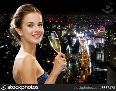 party, drinks, holidays, luxury and celebration concept - smiling woman in evening dress with glass of sparkling wine over night city background