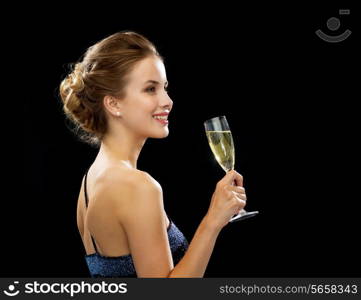 party, drinks, holidays, luxury and celebration concept - smiling woman in evening dress with glass of sparkling wine over black background