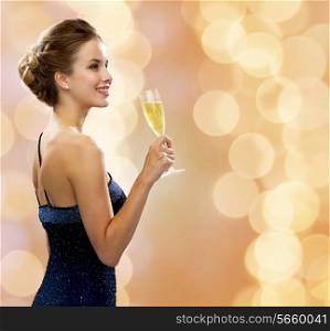 party, drinks, holidays, luxury and celebration concept - smiling woman in evening dress with glass of sparkling wine over beige lights background