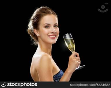 party, drinks, holidays, luxury and celebration concept - smiling woman in evening dress with glass of sparkling wine over black background