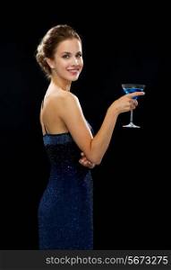 party, drinks, holidays, luxury and celebration concept - smiling woman in evening dress holding cocktail over black background
