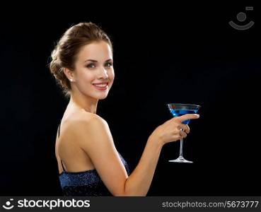 party, drinks, holidays, luxury and celebration concept - smiling woman in evening dress holding cocktail over black background
