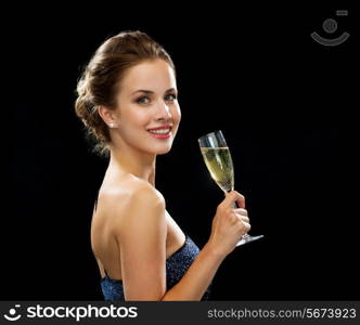 party, drinks, holidays, luxury and celebration concept - smiling woman in evening dress with glass of sparkling wine over black background