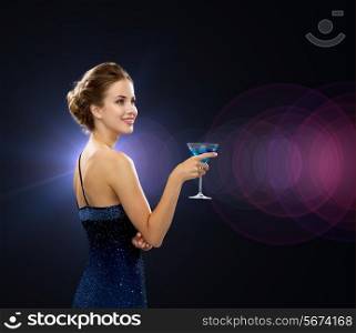 party, drinks, holidays, luxury and celebration concept - smiling woman in evening dress holding cocktail over night lights background