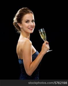 party, drinks, holidays, luxury and celebration concept - smiling woman in evening dress with glass of sparkling wine over black background